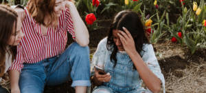 Des femmes assises par terre avec un smartphone