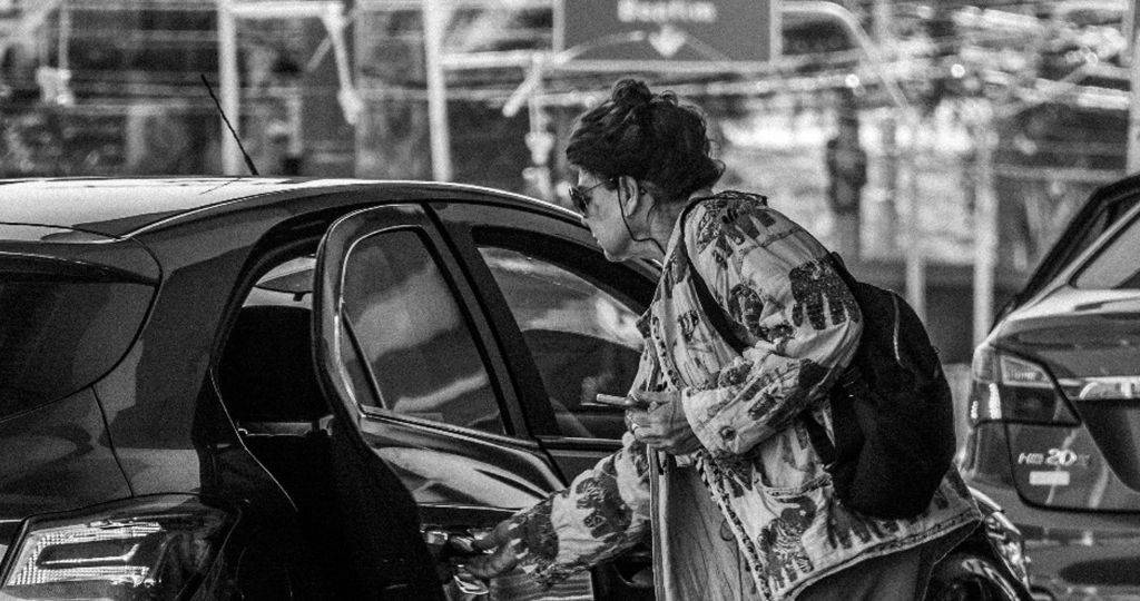Une femme portants a valise monte dans un VTC