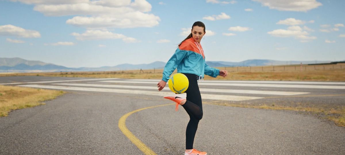 Uber US supporte le football féminin dans sa dernière campagne. Une joueuse de football jongle avec son ballon sur une route désertique