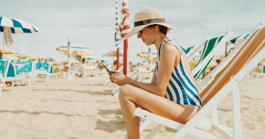 Gérer ses réseaux sociaux en vacances Une femme en maillot de bain à la plage