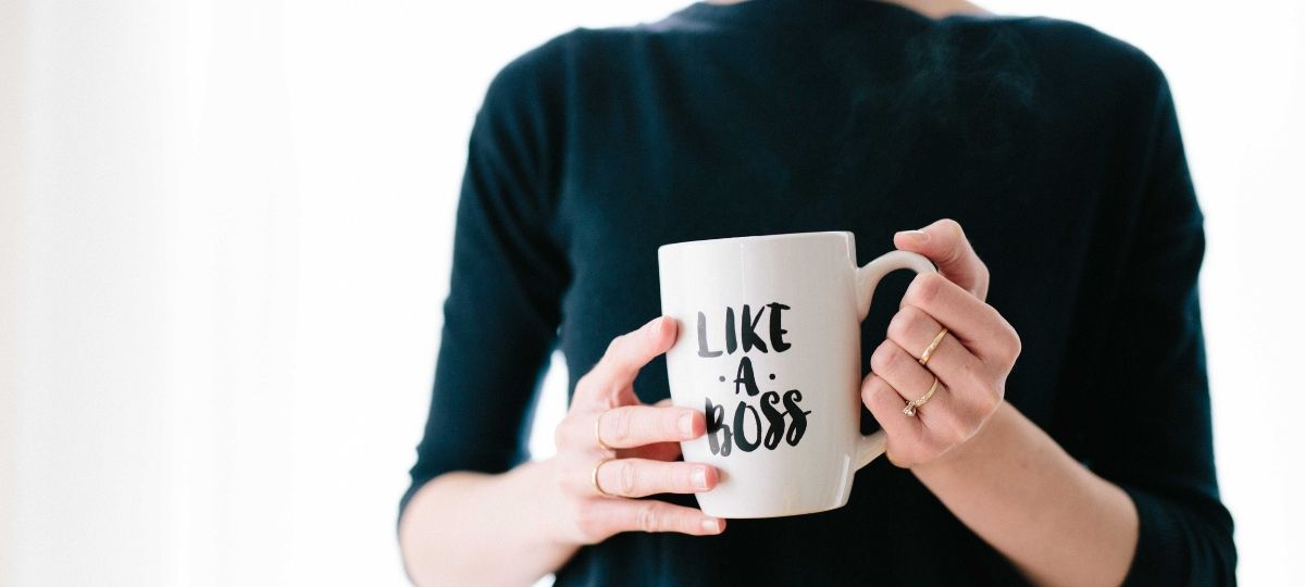 Women’s Forum France et KPMG une femme habillé d'une robe vert nuit porte un mug de café où il est écrit - Like a Boss -
