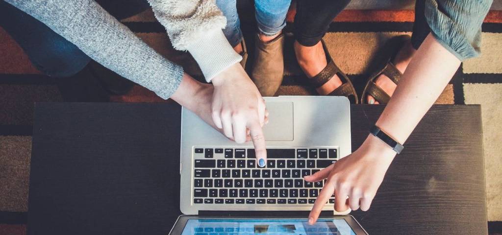 Le reciblage publicitaire, un levier pour convertir plus Trois femmes pointent leurs doigts vers un écran