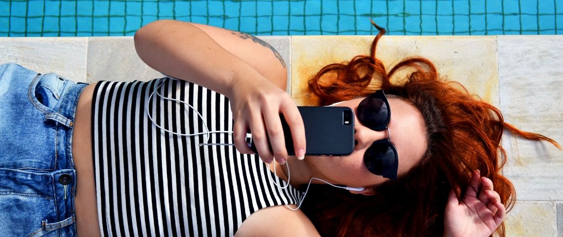 5-etapes-developper-application-mobile Une fille allongée utilise son smartphone
