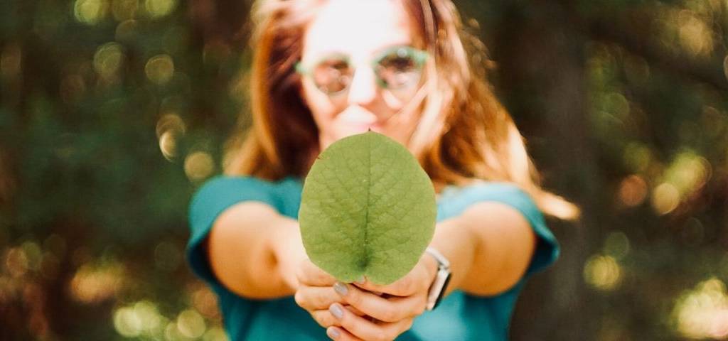 Une femme qui tient une feuille dans sa main