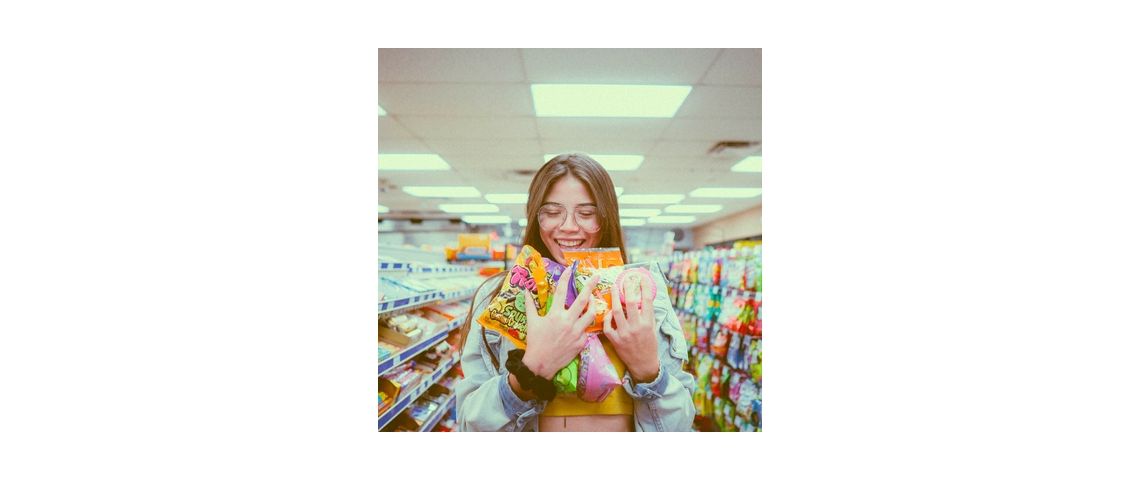 L'INC et 60 Millions de consommateurs lance une application nutritionnelle 3 en 1 Visuel d'une femme au supermarché achetant de nombreuses sucreries