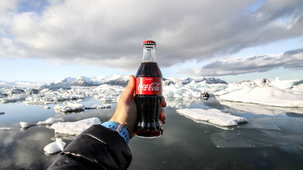 Bouteille de coca cola dans la main d'un homme devant la banquise