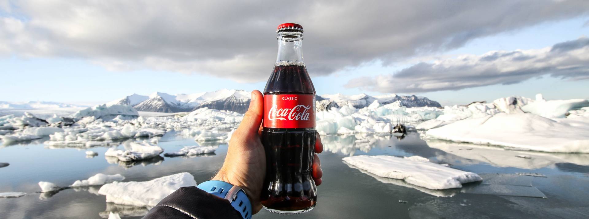 « Parlons-en ensemble ! » Coca-Cola France reçoit des internautes pour répondre aux critiques et démêler le vrai du faux Bouteille de coca cola dans la main d'un homme devant la banquise