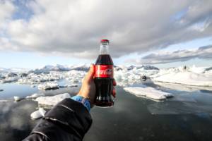 Bouteille de coca cola dans la main d'un homme devant la banquise