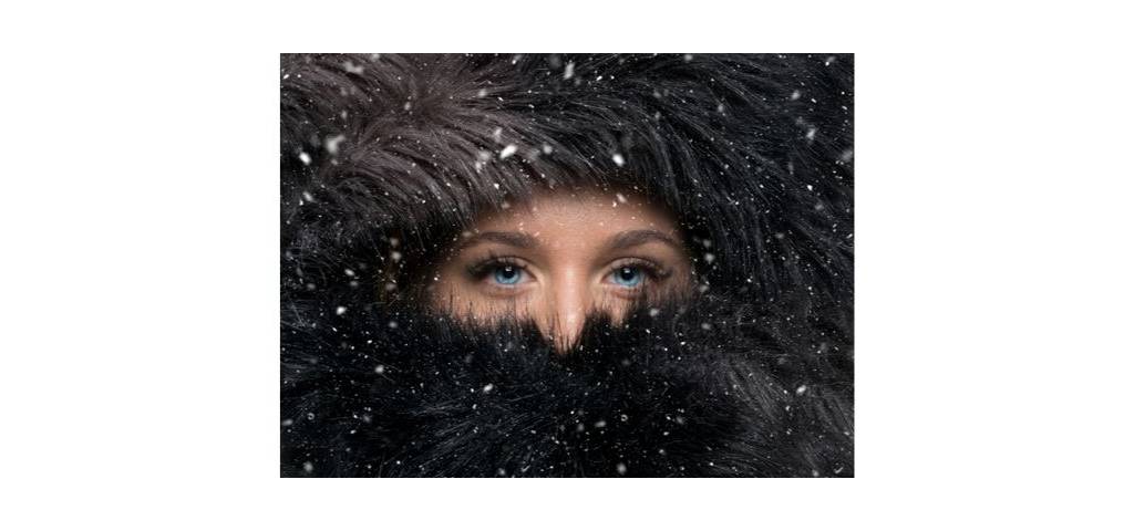 Visuel d'une femme aux yeux bleus avec une fourrure noire