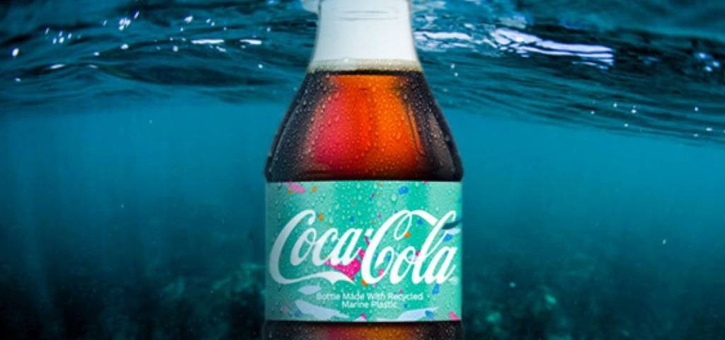 Photo d'une bouteille de coco cola dans l'eau de mer