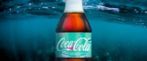 Photo d'une bouteille de coco cola dans l'eau de mer