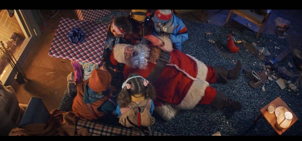 Visuel de la campagne d'Orange avec au centre un père noel allongé entouré des enfants qui l'ont capturé