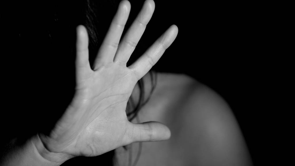 Femme mettant sa main devant son visage pour se protéger