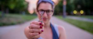 Une femme tenant une fleur entre ses doigts