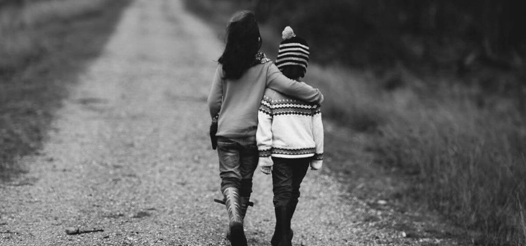 2 enfants de dos sur un chemin se tenant par l'épaule