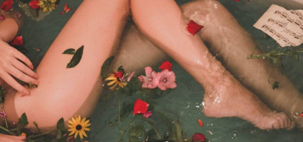 Femme dans un bain avec des fleurs qui flottent