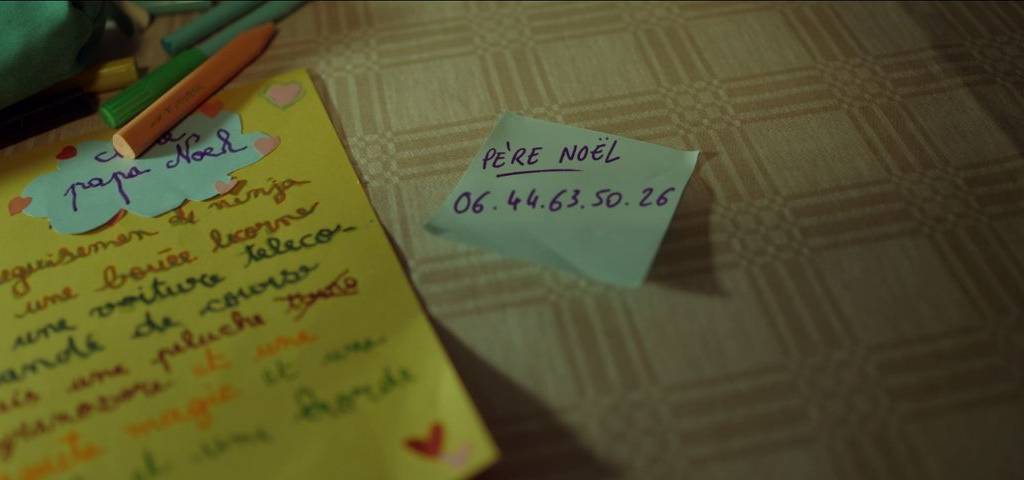 Capture d'écran de la publicité de noel de Bouygutes télécom avec un post-it sur la table avec le numéro de téléphone du père Noel