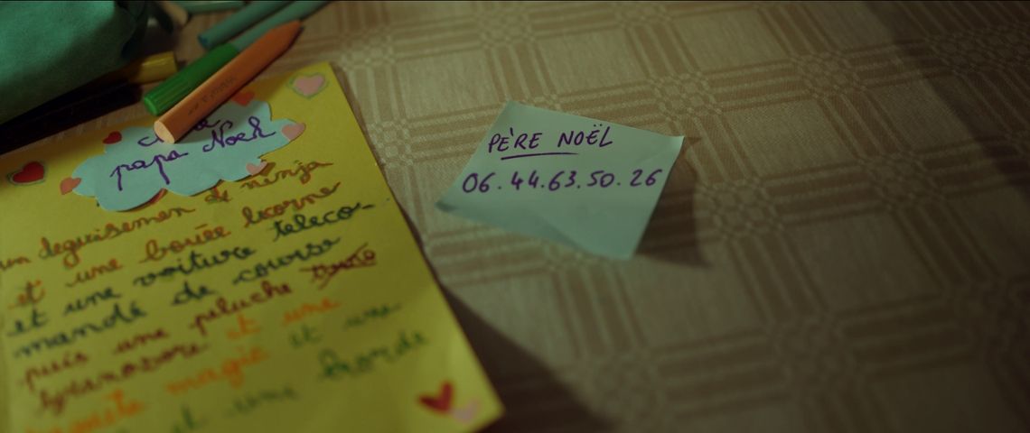 Capture d'écran de la publicité de noel de Bouygutes télécom avec un post-it sur la table avec le numéro de téléphone du père Noel