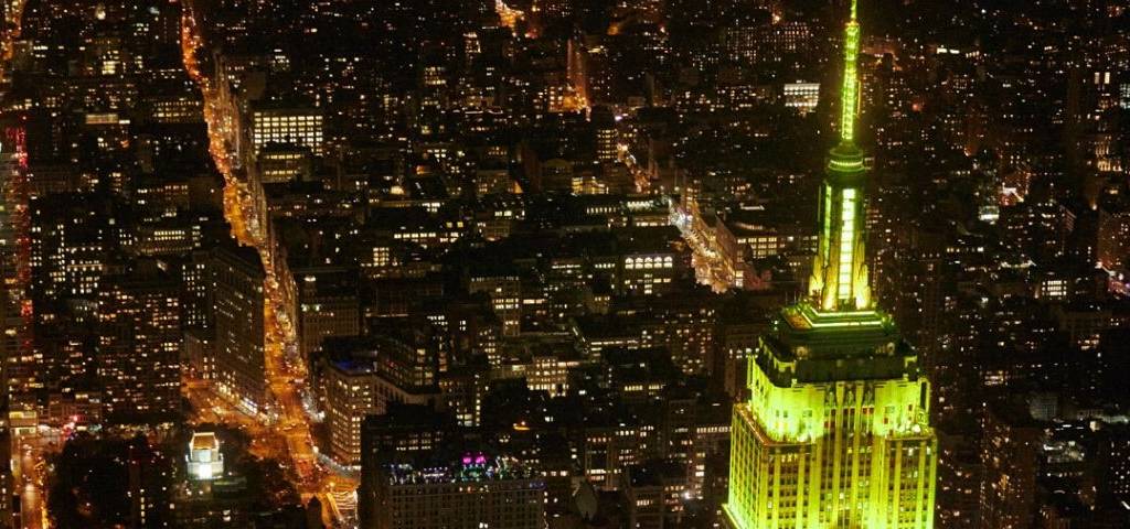 Empire state building de nuit illuminé en jaune