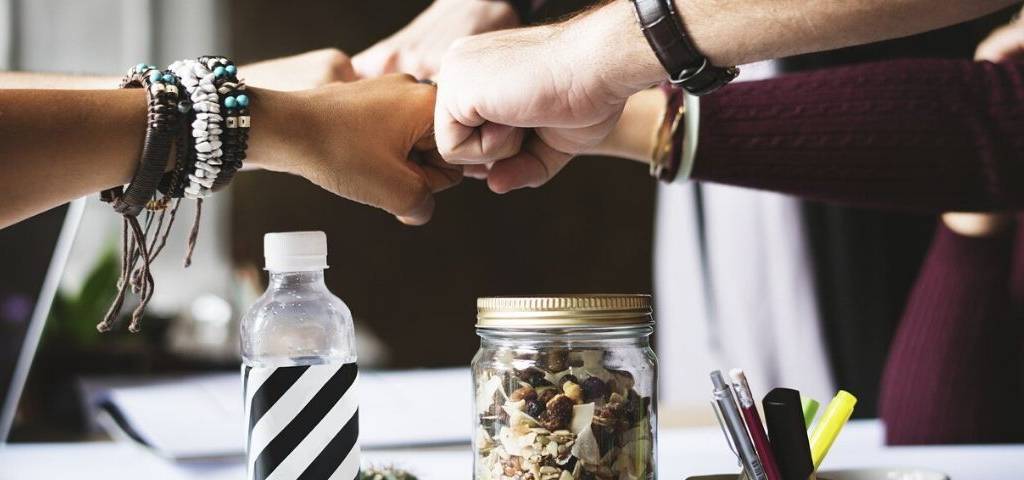 Visuel d'une équipe qui se joint les mains en signe de collaboration