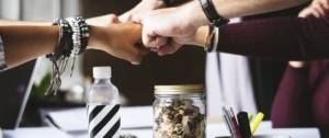 Visuel d'une équipe qui se joint les mains en signe de collaboration