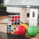 visuel d'un clavier avec 2 rubixcube et 3 balles de couleurs différentes posées devant le clavier