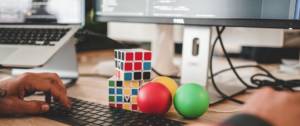 visuel d'un clavier avec 2 rubixcube et 3 balles de couleurs différentes posées devant le clavier