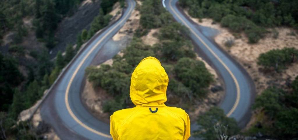 Visuel d'un homme regardant une route sinueuse