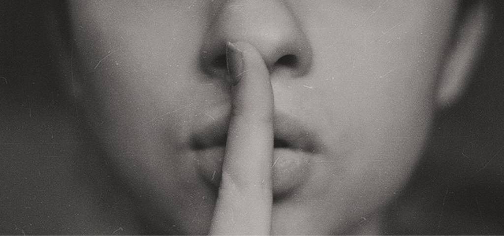 Personne faisant  - chut -  en mettant son doigt devant sa bouche