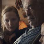 Capture de la publicité d'Apple ppur Noël, avec une famille réunit en trai nde regarder un diaporama sur l'Ipad