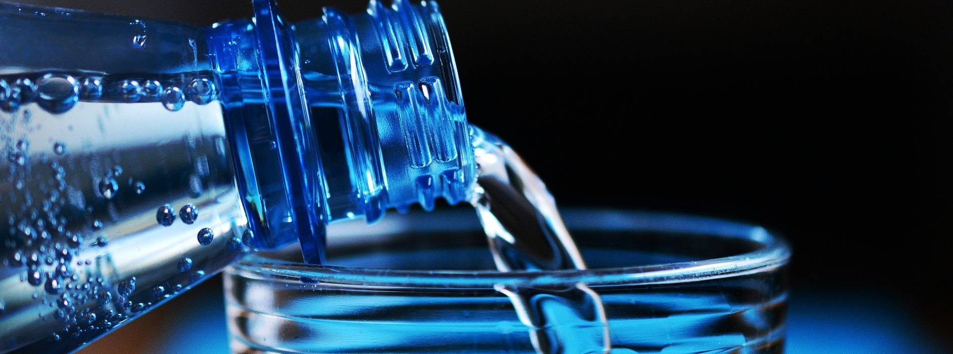 Les marques Eaux de Danone s'engagent à réduire leurs émissions carbone et lutter contre le changement climatique Eau versée dans un verre
