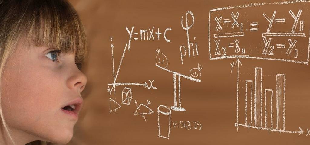 Petite fille regardant de manière dubitative une équation sur un tableau