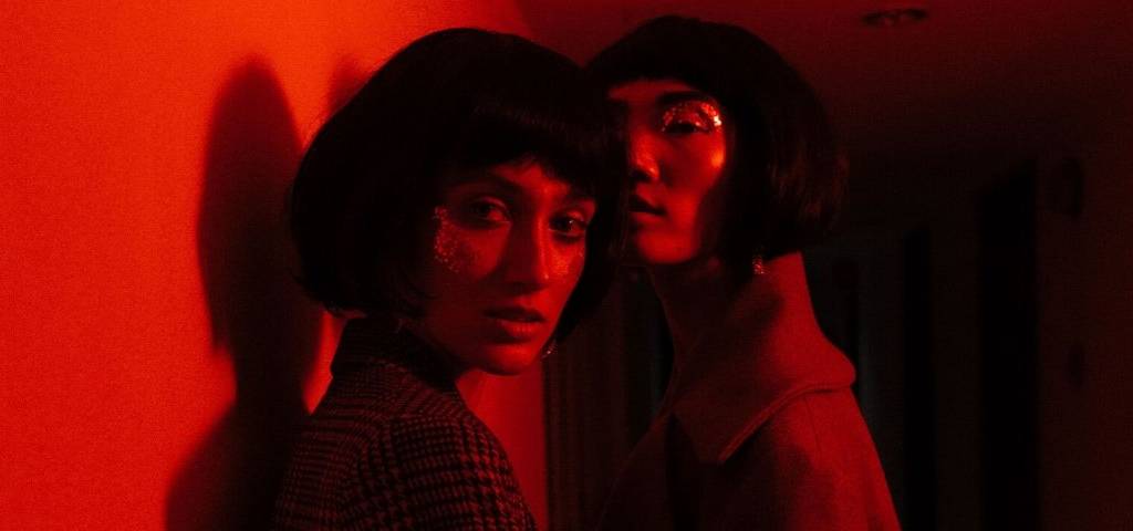 Deux influenceuses se font prendre en photos dans une lumière rouge