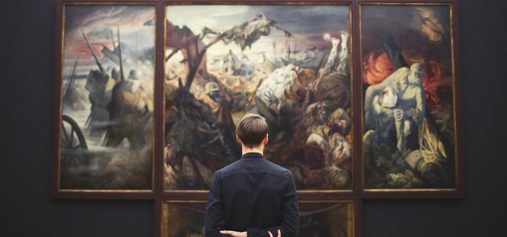 Homme contemplant un tableau au musée