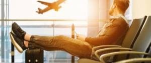 Homme regardant un avion s'envolé assis dans un hall d'aéroport