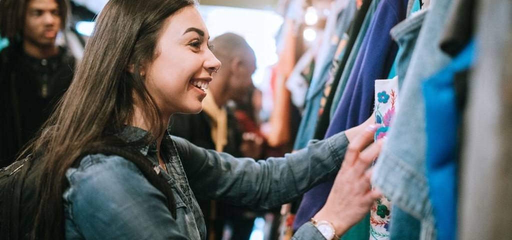 Pourquoi le marché de la seconde main fait revenir les clients en magasin Une jeune femme achète des vêtements dans une friperie