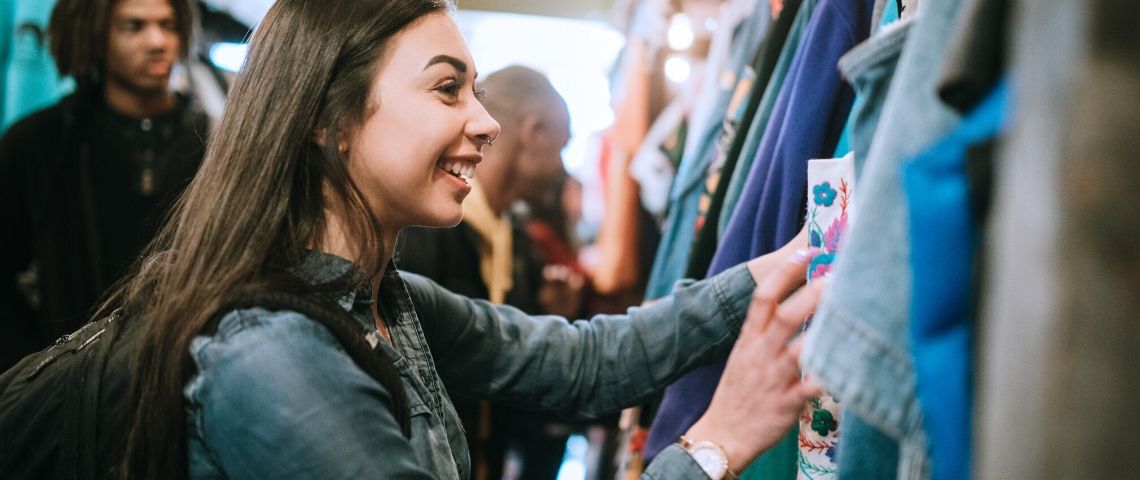Pourquoi le marché de la seconde main fait revenir les clients en magasin Une jeune femme achète des vêtements dans une friperie