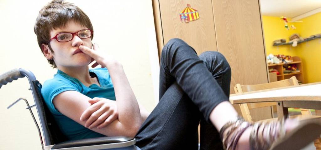 Jeune fille handicapée assise sur une chaise