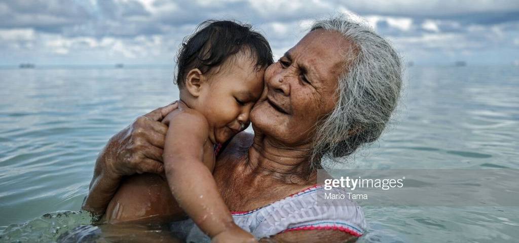 Getty Images et Climate Visuals lancent une bourse afin de faire évoluer les récits visuels représentant la crise climatique mondiale Femme tenant un enfant dans ses bras