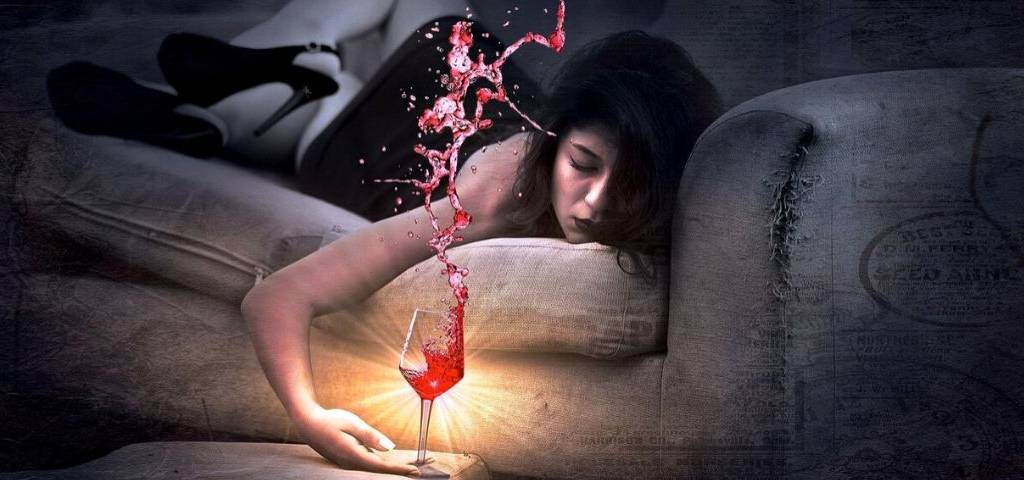 Femme allongé sur un canapé, s'endormant, un verre à la main