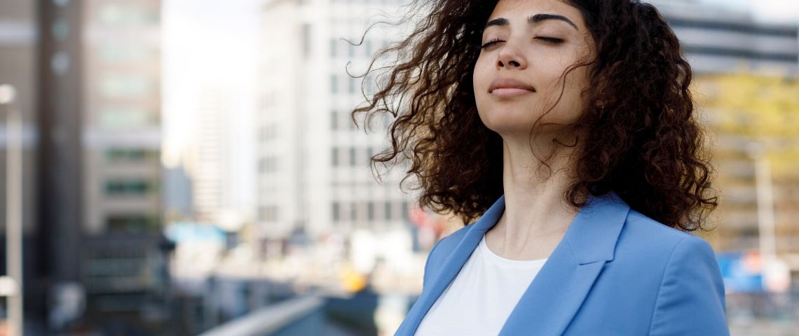 Comment la data impacte le bien-être au travail Une femme médite sur la terrasse d'un immeuble