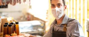 Un homme avec un masque tient un commerce