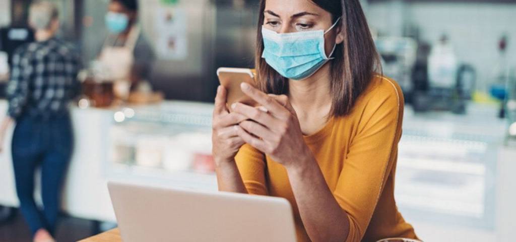 Une femme avec un masque travaille