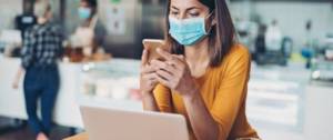Une femme avec un masque travaille