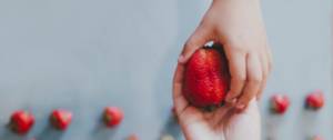 Un enfant donne une fraise
