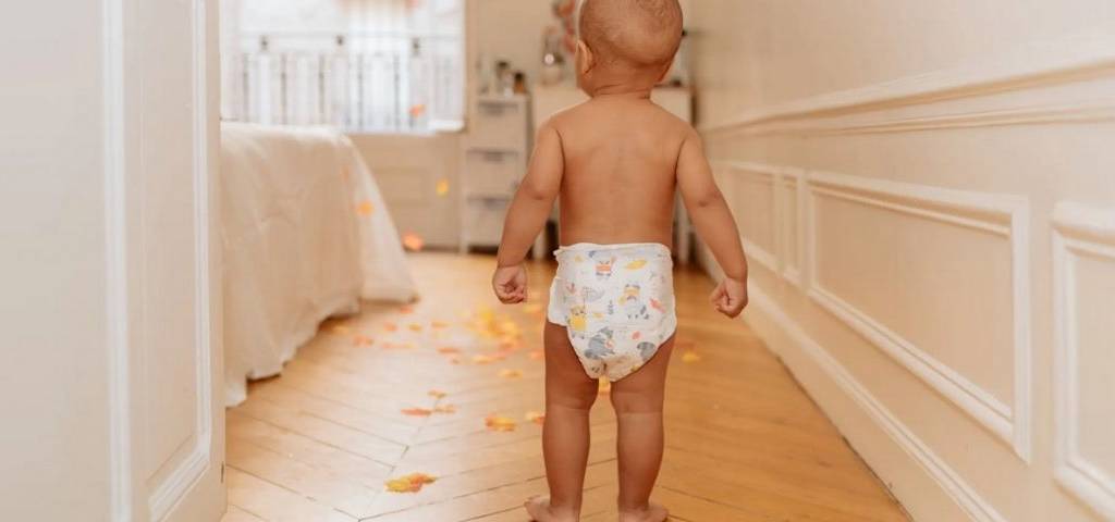 Bébé marchand de dos avec une couche