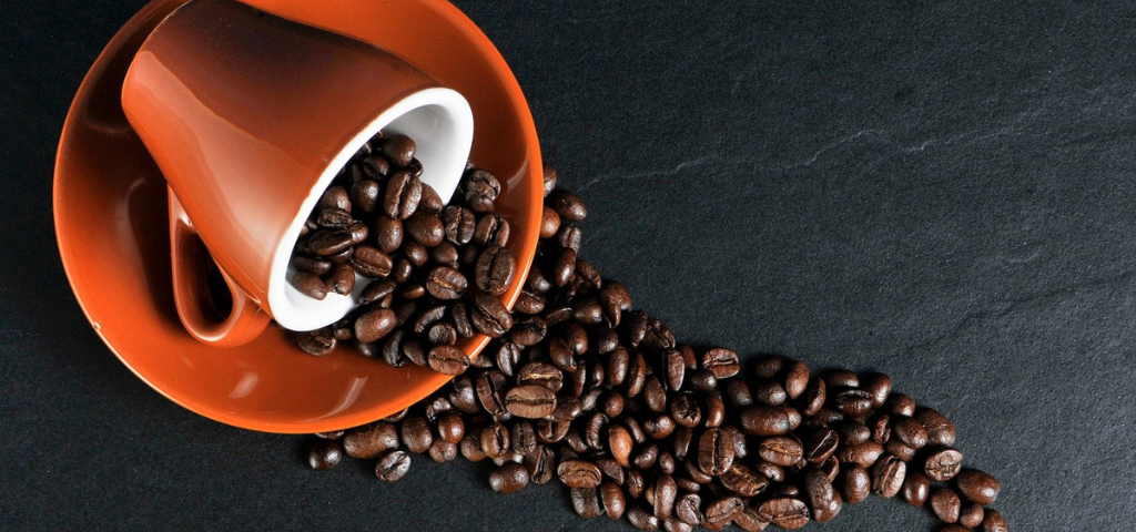 Tasse de café, renversée, avec des grains