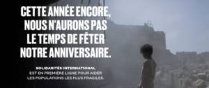 Solgan de la campagne : Cette année encore, nous n'aurons pas le temps de fêter notre anniversaire. Avec en arrière plan un enfant sur des débris d'immeubles suite à un bombardement
