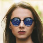 Jeune fille portant des lunettes de soleil dans lesquelles se reflète le drapeau européen