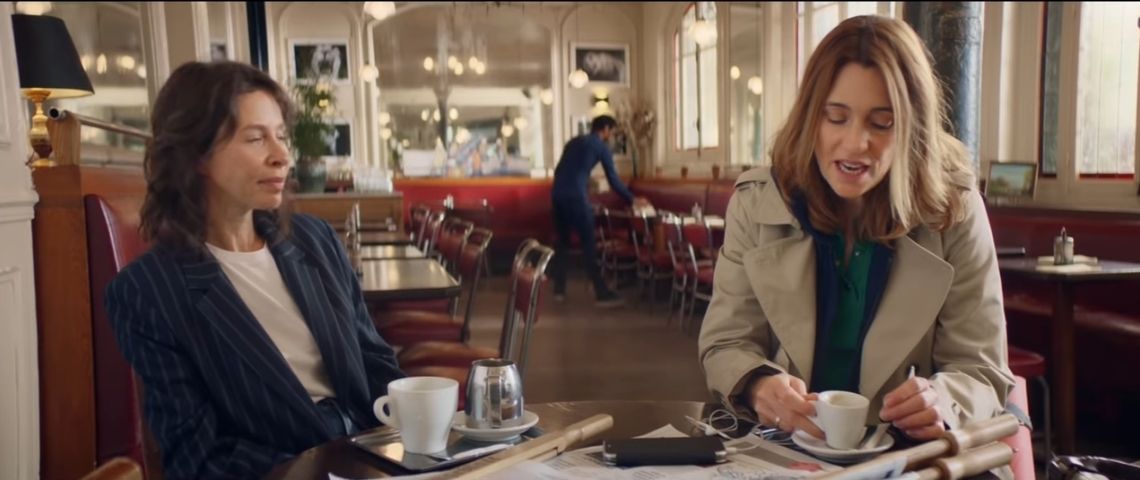 Monoprix lance son nouveau service e-commerce - Monoprix Plus - accompagné par son agence Babel Capture de la campagne : 2 femmes assises à la table d'un café